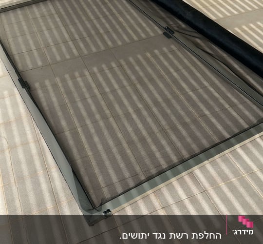 אדם מתקין מסגרת אלומיניום לרשת על הרצפה